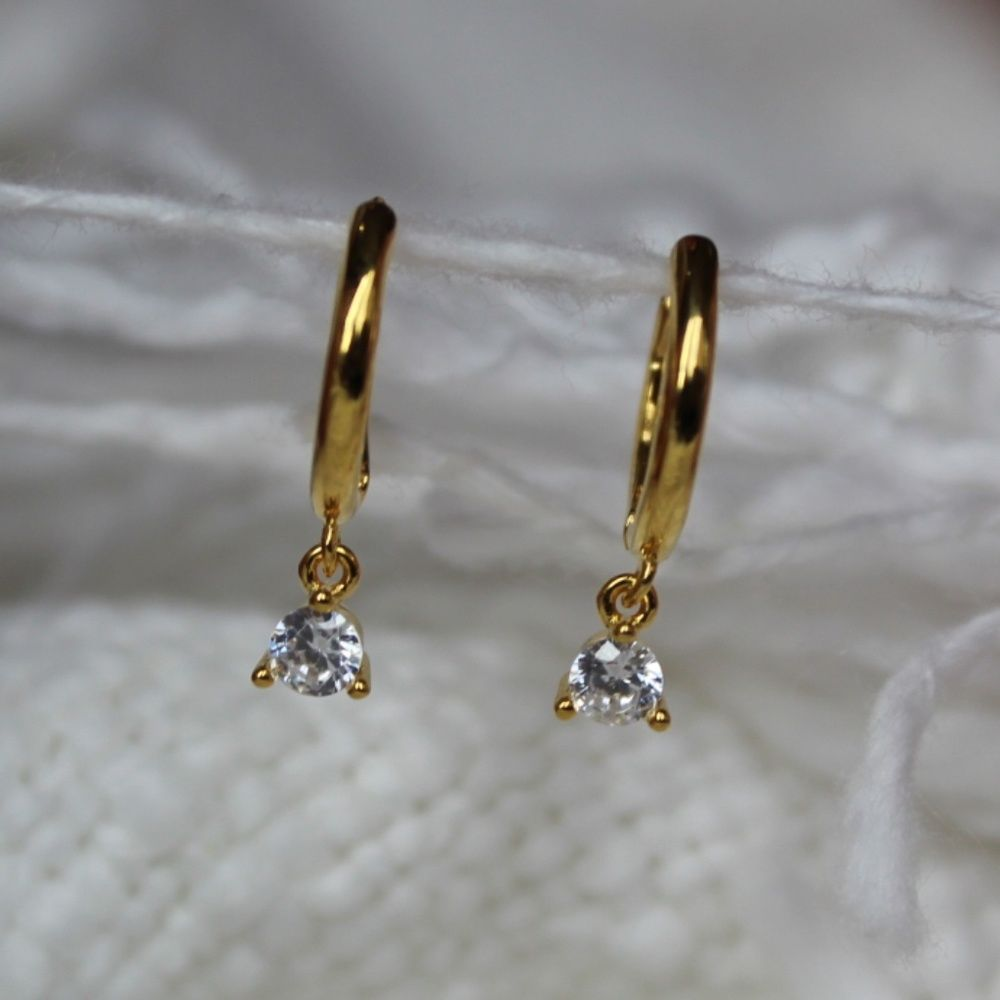 gold hoops with charms hanging